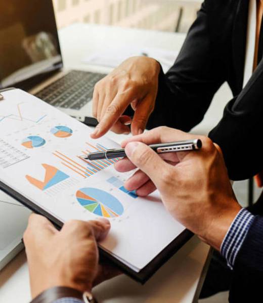 Business concept. Business people discussing the charts and graphs showing the results of their successful teamwork. Selective focus.